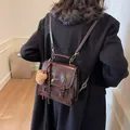Mochila vintage de cuero sintético marrón oscuro con hebilla y colgante de oso peluche - 20x9x20cm / Café Con Colgante De Conejo