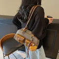 Retro Boston pillow bag in olive canvas with brown leather pockets shown on model - Dark Tea With Charm