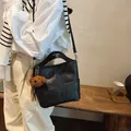 Borsa a secchiello minimalista in pelle nera con ciondolo a orsetto e tracolla rimovibile - Con Ciondolo / Nero