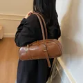 Brown leather cylinder shoulder bag with silver buckle detail on a female model - 37*10*13 / Brown