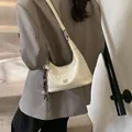 White glossy crescent shoulder bag with adjustable strap and decorative charm - White With Pendant / White