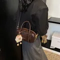 Dark brown glossy Boston bag with plush sheep pendant and adjustable crossbody strap - With Pendant / Brown