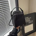 Minimalist black nylon shell bag with decorative rope strap and dual zippers - Black
