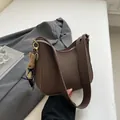 Dark brown pebble leather crescent crossbody bag with widened strap and rabbit charm - 24x7x20.5cm / Brown And Rabbit Charm