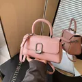 Elegant pink square handbag with silver buckle and adjustable strap shown in mirror reflection - 22x8x13cm / Pink