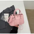 Detailed macro view of pink lychee grain leather bucket bag with metallic round button - Pink Without Pendant