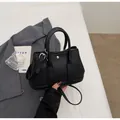 Minimalist black pebbled leather bucket bag with top handles and silver buckle detail - Black without Pendant