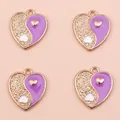 Close-up of heart-shaped Yin Yang charms in purple and gold for DIY jewelry making - Purple