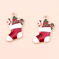 Close-up of alloy Christmas stocking pendants with red enamel and candy cane details - Red