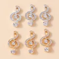 Macro-detail van gouden en zilveren G-sleutel hangers met strass voor DIY sieraden - Meerkleurig