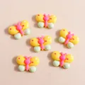Detail van kleurrijke vlinderharsbedeltjes voor DIY-telefoonhoesjes en knutselwerk - Geel