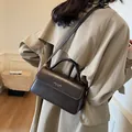 Vintage dark brown crossbody leather square bag shown with classic khaki trench coat outfit - Coffee