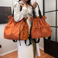 Orange drawstring nylon backpack tote set featuring functional front pockets and dual handles - Orange / Large