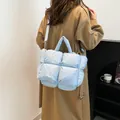Light blue quilted puffer handbag with glossy finish and adjustable shoulder strap - Blue