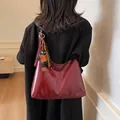 Chic burgundy patent leather oversized tote bag worn over the shoulder on black blazer - Wine Red with Pendant
