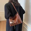 Retro brown high-gloss leather tote bag with fluffy charm shown in a minimalist interior - Brown with Pendant