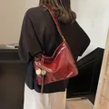 Elegant large burgundy leather tote bag with wide strap and pendant shown on model - Wine Red With Pendant