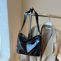 Glossy black patent leather tote bag with gold hardware and geometric stitching detail - Black