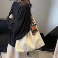 Large cream-white leather tote bag with creative character charm and glossy finish - Off-white With Pendant
