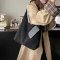 Black faux shearling tote bag with leather pocket shown on model in cafe setting - Black