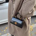 Retro schwarze Trapez-Handtasche aus Leder mit goldenen Beschlägen und Tragegriff - Schwarz