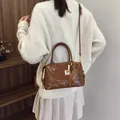 Sac bandoulière vintage en cuir marron avec breloques dans un décor chic - Avec Pendentif / Marron