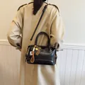 Retro black Boston bag with decorative charms and adjustable strap shown on shoulder - With Pendant / Black