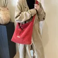 Sac fourre-tout rouge en peluche de laine avec cordon porté par un mannequin - 38x10x34cm / Bandoulière Rouge