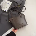 Minimalist dark brown leather bucket bag for women with dual handles and long shoulder strap - No Pendant / Coffee