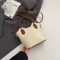 Retro cream and brown crossbody bucket bag with adjustable strap on a stylish background - No Pendant / Off White