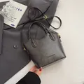Minimalist black matte leather bucket bag with top handle and adjustable shoulder strap - No Pendant / Black