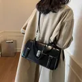 Klassieke zwarte vintage schoudertas gedragen door model in beige trenchcoat voor mode 2025 - Zwart