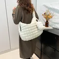 Quilted white cloud shoulder bag with mini pouch shown on model in a modern room - Shoulder Bag And Small Pouch Set / White