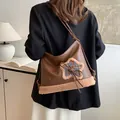 Dunkelbraune Leder-Tragetasche mit Plüschbesatz und Sternen-Patch, von Model getragen - Braun