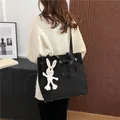 Minimalistische zwarte canvas shopper met wit konijnenhangertje en lederen schouderband - Met Konijnenhanger / Zwart