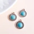 Drie vintage zilveren boho-bedels met turquoise steen en touwrand op beige achtergrond - Zilveren Stijl / Zilver