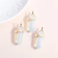 Three hexagonal opal crystal pendants with gold metal caps on a pink background - Gold