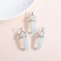 Three hexagonal opal crystal pendants with silver metal loops on a beige background - Silver