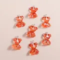 Gros plan de pendentifs ours en résine orange avec paillettes dorées et anneaux en argent - Pack de 15 / Rouge