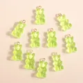 Macro view of light green gummy bear resin charms with golden hanging loops for DIY crafts - Green