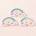 Detail of three resin rainbow cloud charms with small hearts for DIY phone case decor - Blue Heart Rainbow