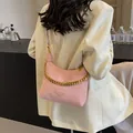 Pink hobo bucket bag with chunky gold chain and leather strap on a stylish model - Small / Pink