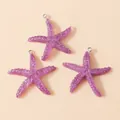 Macro detail of three purple resin starfish charms with silver hanging loops for DIY jewelry - Purple