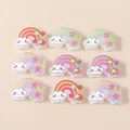 Flat lay of nine rainbow resin accessories with smiling clouds for DIY crafts decoration - Multicolor