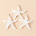 Macro detail of translucent resin starfish charms with iridescent glitter and metal loops - White