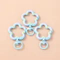 Close-up of light blue flower-shaped metal lobster clasps with painted stripe details - Blue