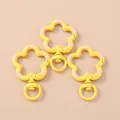 Macro view of three yellow star-shaped lobster clasps with pink dots and swivel rings - Yellow