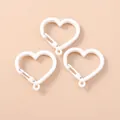 Dettaglio di tre chiusure a molla bianche a forma di cuore per gioielli fai-da-te - Bianco