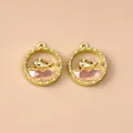 Detailed macro view of golden whale pendant charms with pink crystal inlay for DIY jewelry - Gold Pink