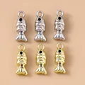 Close-up van gouden en zilveren koi-visbedeltjes voor DIY-sieraden op beige achtergrond - Meerkleurig